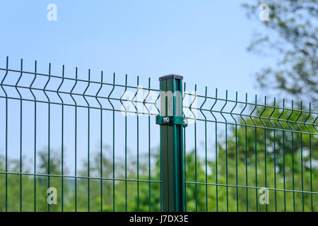 Close-up of a metal fence wire on blue sky background Stock Photo