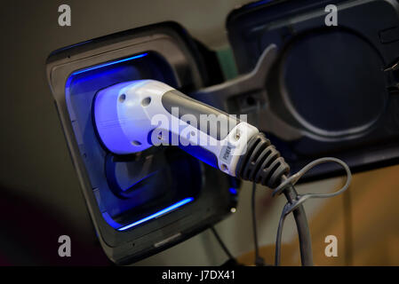 Power supply plugged into an electric car during charging. Stock Photo