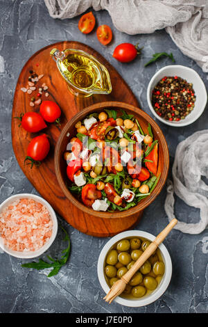 Spring vegetable salad with arugula, cherry tomatoes, chickpeas, olives and feta cheese. Buddha bowl. Healthy, vegan, detox food. Top view Stock Photo