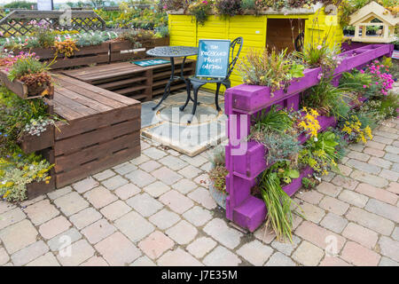 A recycled pallet display in a garden centre with furniture made from discarded wooden pallets Stock Photo