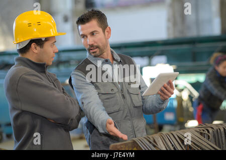 construction worker pointing at digital tablet close-up Stock Photo