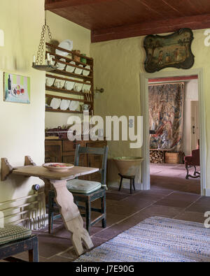 Swiss Engadine wall table with a pair of old English chairs with 19th century Dutch painting on wood Stock Photo