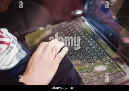 Professional man with a laptop in car tunes tuning control system, updating software, gaining access through to computer, sitting in cabin Stock Photo