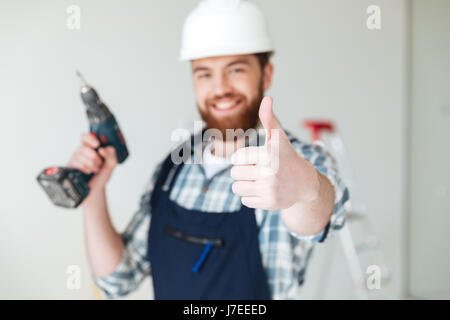 Close up of smiling man builder showing thumb up isolated Stock Photo