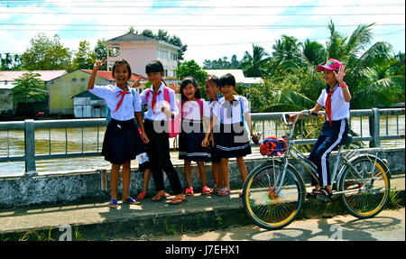 Happy Vietnamese kids, on a bridge in the Mekong Delta, Vietnam Stock Photo