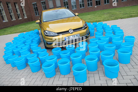 114 buckets with 10 liters of water each stand around a VW Golf in the facilities of the Volkswagen factory in Wolfsburg, Germany, 19 May 2017. Volkswagen has since 2010 reduced the amount of water needed for the production of a single Golf car to 1140 liters, mainly through technological advances in the painting process. Volkswagen is a partner in the Open Hybrid Lab Factory in its Wolfsburg facilities, a research and development center with partners from the manufacturing industry such as auto manufacturer Volkswagen, the Fraunhofer Institute, Technological Universities and the Federal Gover Stock Photo