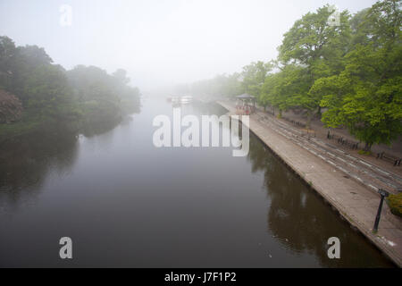 A view down the River Dee on a foggy summers morning from the suspension bridge that crosses the river dee, Chester, England, UK Stock Photo