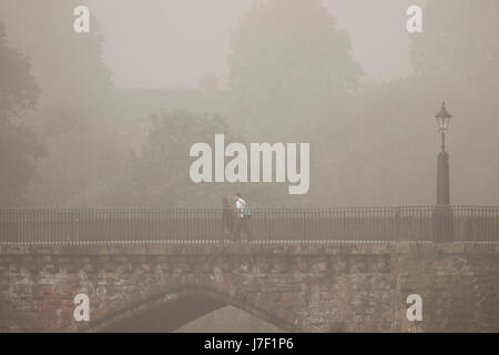 A foggy summers morning as school children cross over the River Dee in Chester over the Grosvenor Bridge, England, UK Stock Photo