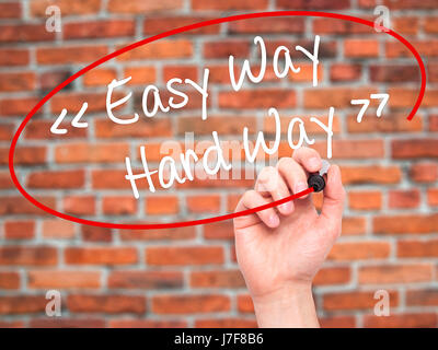 Man Hand writing Easy Way - Hard Way with black marker on visual screen. Isolated on background. Business, technology, internet concept. Stock Photo Stock Photo