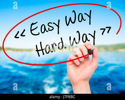 Man Hand writing Easy Way - Hard Way with black marker on visual screen. Isolated on background. Business, technology, internet concept. Stock Photo Stock Photo
