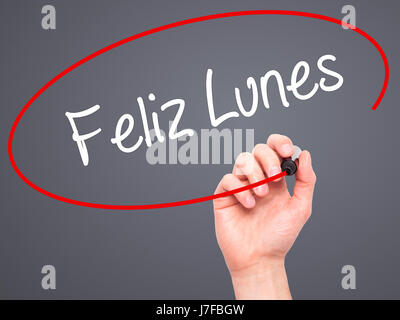 Man Hand writing Feliz Lunes (Happy Monday In Spanish) with black marker on visual screen. Isolated on grey. Business, technology, internet concept. S Stock Photo