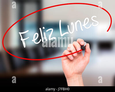 Man Hand writing Feliz Lunes (Happy Monday In Spanish) with black marker on visual screen. Isolated on office. Business, technology, internet concept. Stock Photo