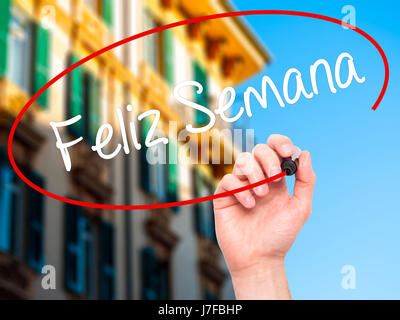 Man Hand writing Feliz Semana  (Happy Week in Spanish/Portuguese) with black marker on visual screen. Isolated on background. Business, technology, in Stock Photo