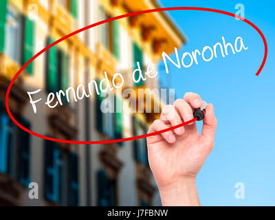 Man Hand writing Fernando de Noronha with black marker on visual screen. Isolated on city. Business, technology, internet concept. Stock Photo Stock Photo