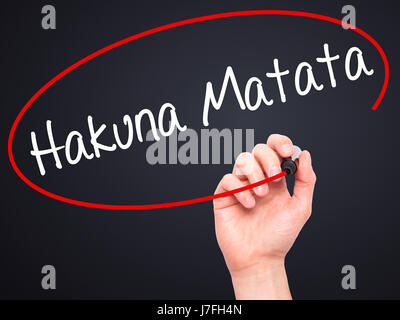 Man Hand writing Hakuna Matata (Swahili phrase; it means &quot;no worries&quot;) with black marker on visual screen. Isolated on black. Business, tech Stock Photo