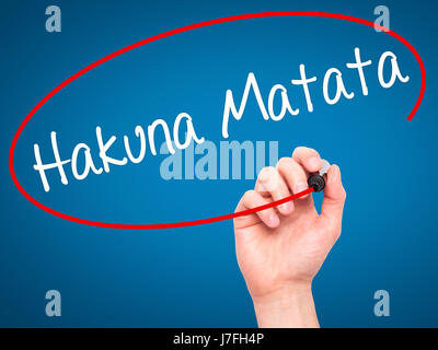 Man Hand writing Hakuna Matata (Swahili phrase; it means &quot;no worries&quot;) with black marker on visual screen. Isolated on blue. Business, techn Stock Photo