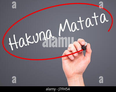 Man Hand writing Hakuna Matata (Swahili phrase; it means &quot;no worries&quot;) with black marker on visual screen. Isolated on grey. Business, techn Stock Photo