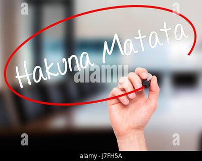 Man Hand writing Hakuna Matata (Swahili phrase; it means &quot;no worries&quot;) with black marker on visual screen. Isolated on office. Business, tec Stock Photo