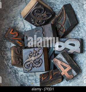 Old wooden letterpress block type of different fonts in a rustic bowl. Letters for printing. Bold letter press blocks. Stock Photo