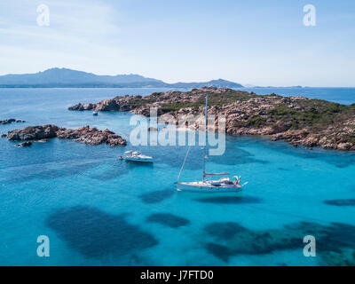 Aerial view of a boat in front of the Mortorio island in Sardinia. Amazing beach with a turquoise and transparent sea. Emerald Coast, Sardinia, Italy. Stock Photo