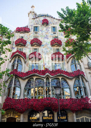 Casa Batlló, designed by Antoni Gaudi, adorned with red rosettes celebrating Sant Jordi Day, Barcelona, Spain. Stock Photo