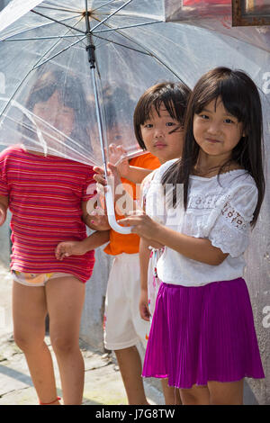 Young Chinese children with an umbrella, Shanghai, China Stock Photo