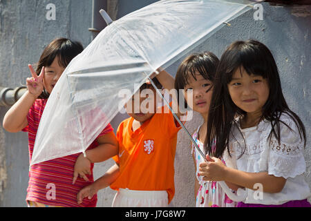 Young Chinese children with an umbrella, Shanghai, China Stock Photo