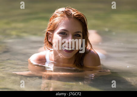 Young woman smiling, lying in the water Stock Photo