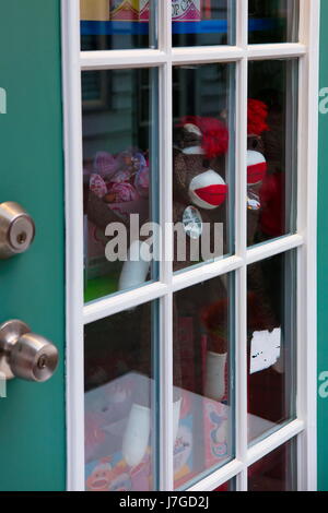 Sock Monkey Dolls Behind a Glass Door Stock Photo