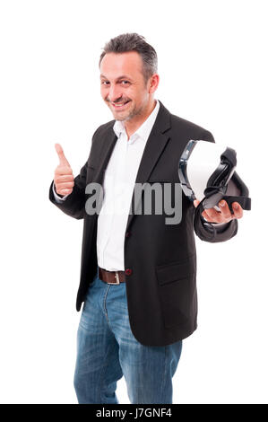 Cheerful male enjoy using virtyal reality goggles and doing thumb up sign isolated on white background Stock Photo
