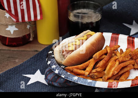 Hot dogs with Mustard at a 4th of July BBQ picnic. Extreme shallow depth of field with selective focus on wieners. Stock Photo