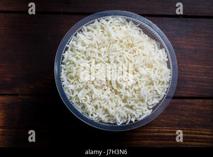 a bowl of boiled rice on a wooden table Stock Photo