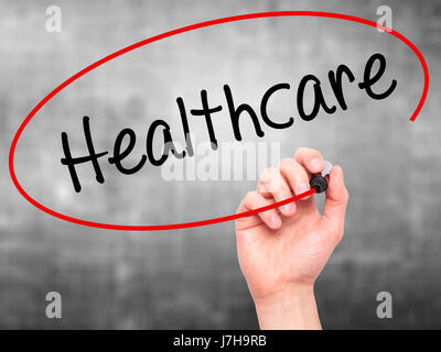 Man Hand writing Healthcare with black marker on visual screen. Isolated on grey. Business, technology, internet concept. Stock Photo Stock Photo