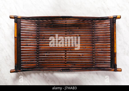 Authentic tray of natural bamboo on a white marble table Stock Photo
