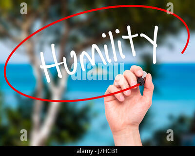 Man Hand writing Humility  with black marker on visual screen. Isolated on background. Business, technology, internet concept. Stock Photo Stock Photo