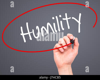 Man Hand writing Humility  with black marker on visual screen. Isolated on background. Business, technology, internet concept. Stock Photo Stock Photo