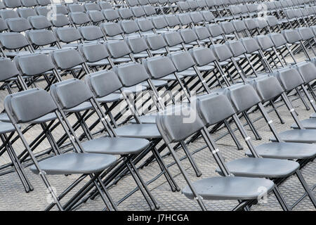 rows of empty chairs - black folding chairs Stock Photo