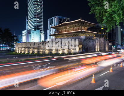 Traffic, captured with blurred motion, rushes around the Dongdaemun gate at night in Seoul, South Korea capital city. The gate was part of the Seoul c Stock Photo