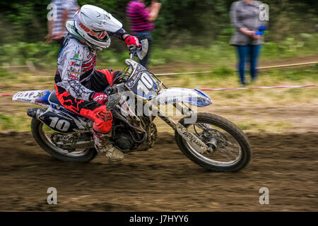 Uzhgorod, Ukraine - May 21, 2017: MX rider turns on a corner. Motion blur with flying dirt. TransCarpathian regional Motocross Championship Stock Photo