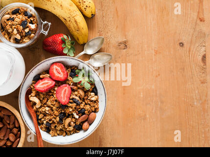 Granola, muesli, breakfast cereals, fresh fruits and milk. Healthy breakfast, healthy eating, diet food. Top view and copy space Stock Photo