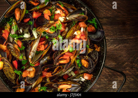 Skillet of marinara mussels on rustic background with copyspace Stock Photo
