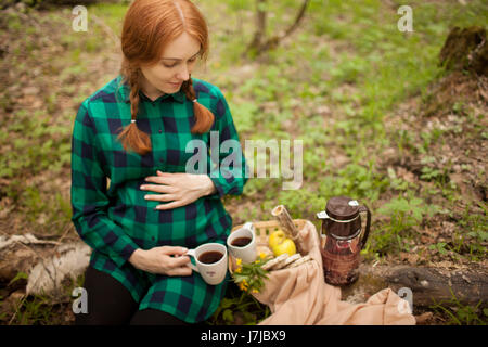 pregnant girl in the woods on a picnic Stock Photo