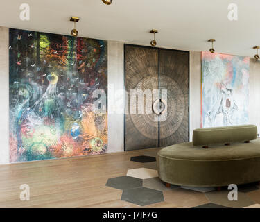 1950s beaten bronze double doors with large modern artwork in Istanbul apartment Stock Photo