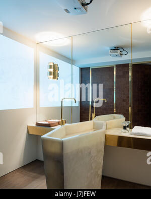 Brass fittings with full length mirror and reflection of marble washstand Stock Photo