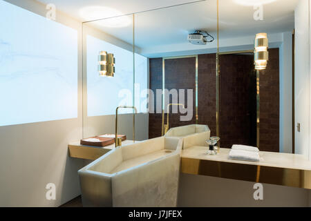 Brass fittings with full length mirror and reflection of marble washstand Stock Photo