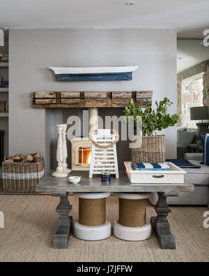 A pair of capstan stools under thick-set wooden coffee table in sitting room with jotul wood stove. the walls are painted in French Dark Grey by Littl Stock Photo