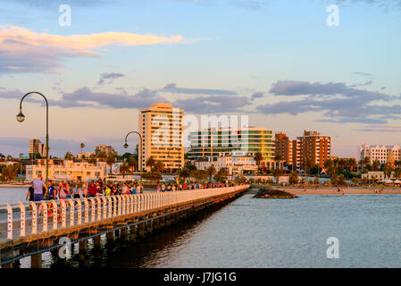 Melbourne, Australia - December 28, 2016: People walking along St. Kilda Beach jetty at sunset on a hot summer day Stock Photo