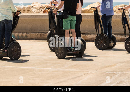 A group of people are riding on electric scooter Stock Photo