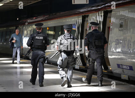 Armed British Transport Police Specialist Operations officers wait to board a Virgin train to Birmingham New Street at Euston station in London as armed police officers are patrolling on board trains nationwide for the first time. Stock Photo