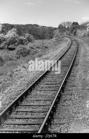 A single track rural standard gauge railway line on a curve  in Black and White Stock Photo